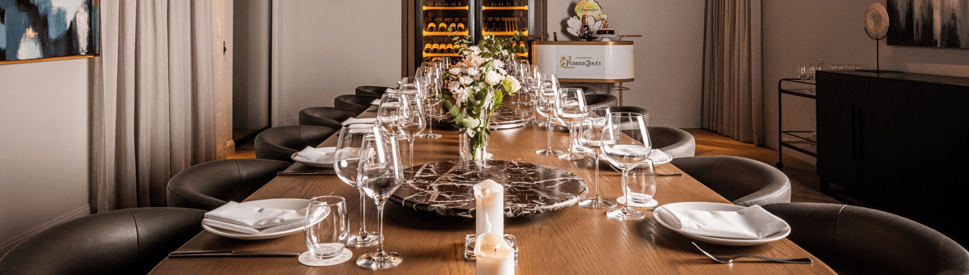 The private dining room at Sydney Common set for a celebration, with a marble lazy-susan table, black leather chairs and champagne