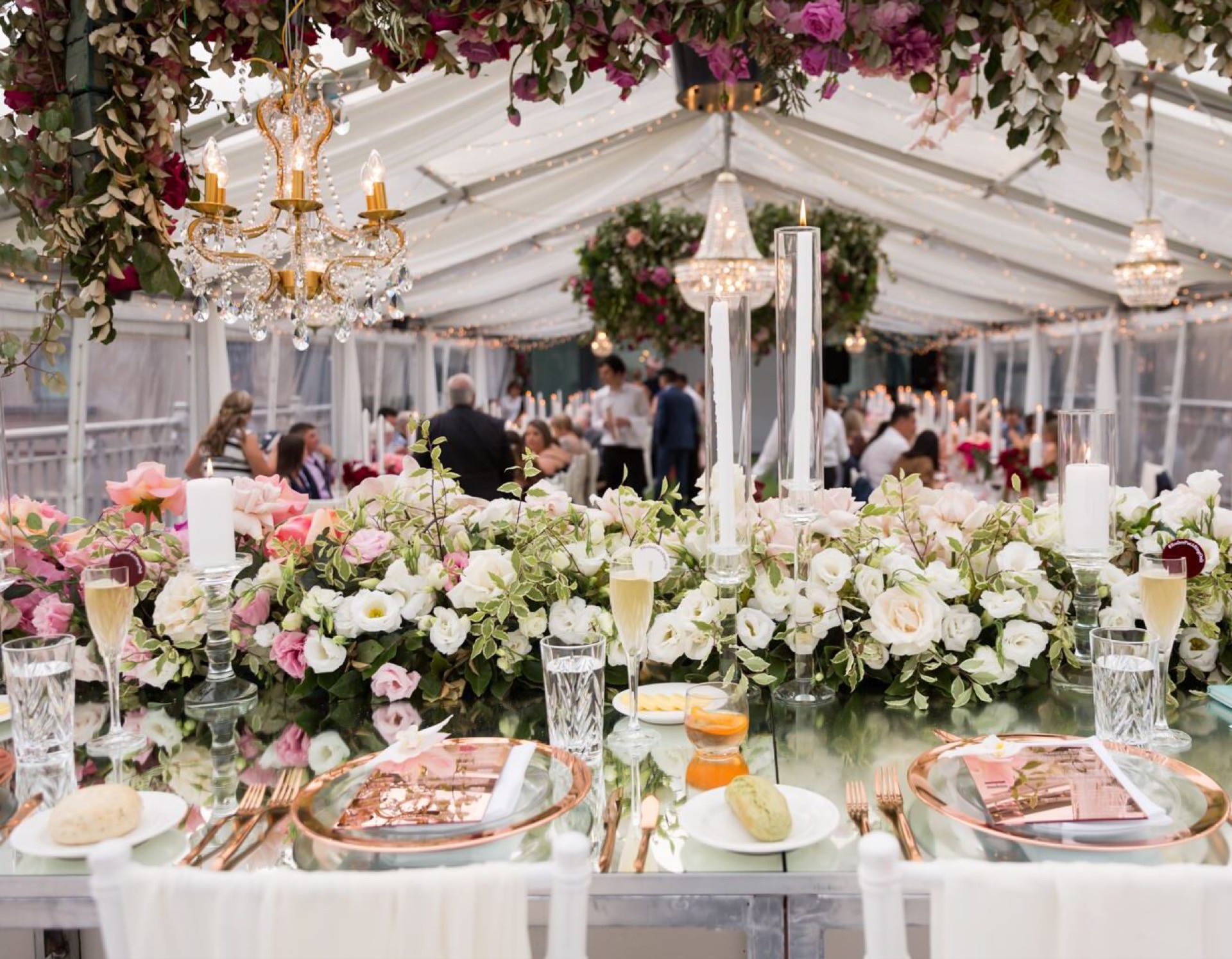 Guests seated at a floral-styled long table in the marquee at Pier One Sydney Harbour