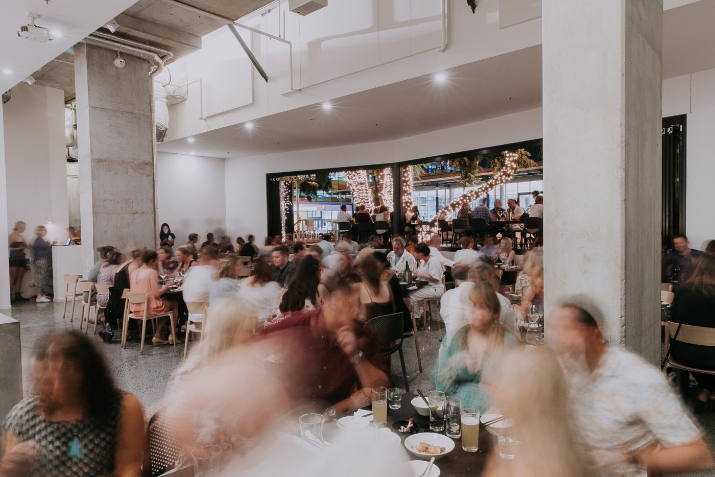 Happy Boy's main dining hall, a full room with high ceilings, concrete columns and clean white lines