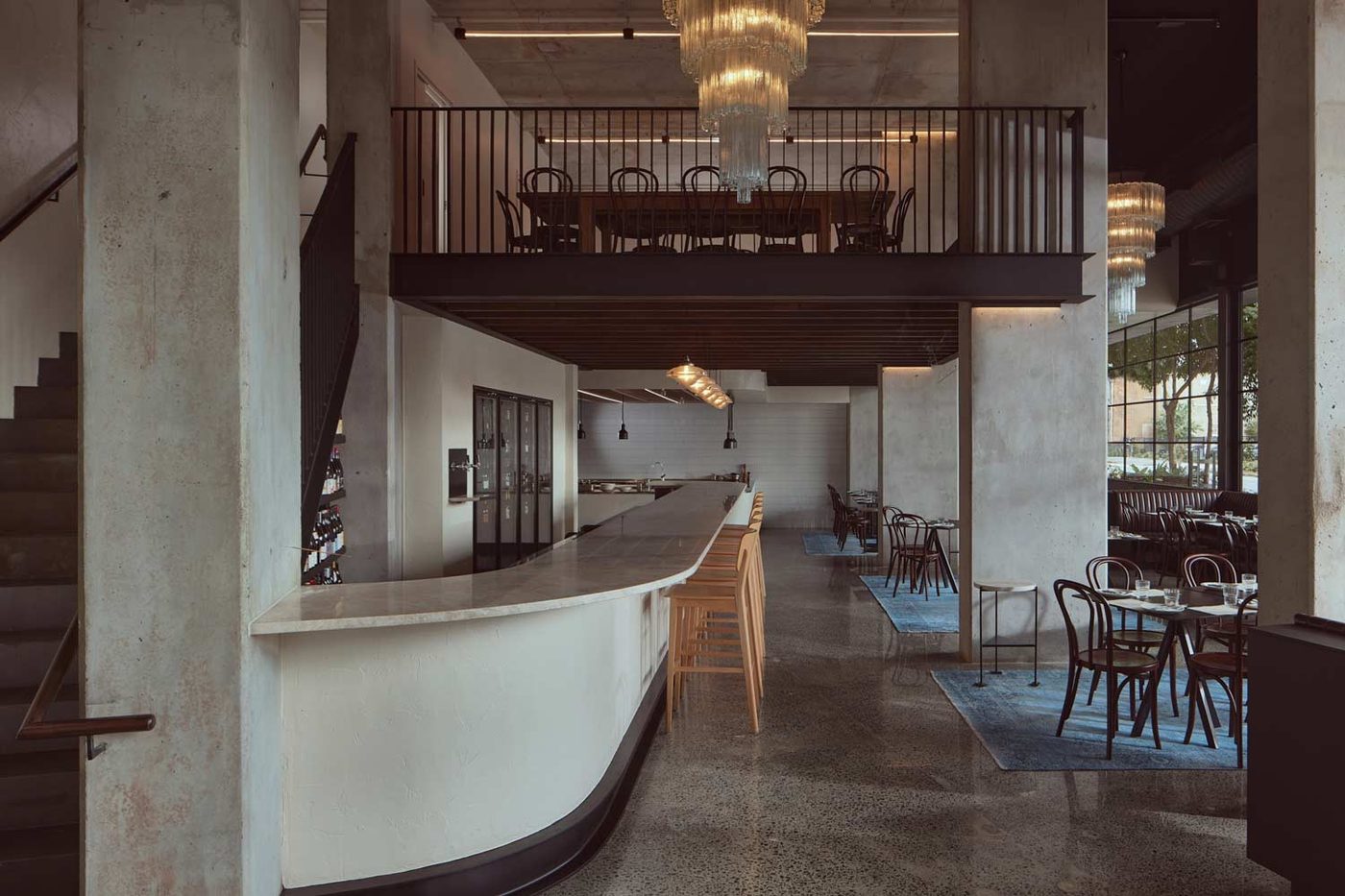 Petite's corner bistro interior with a marble bar, mezzanine level and Murano glass chandelier