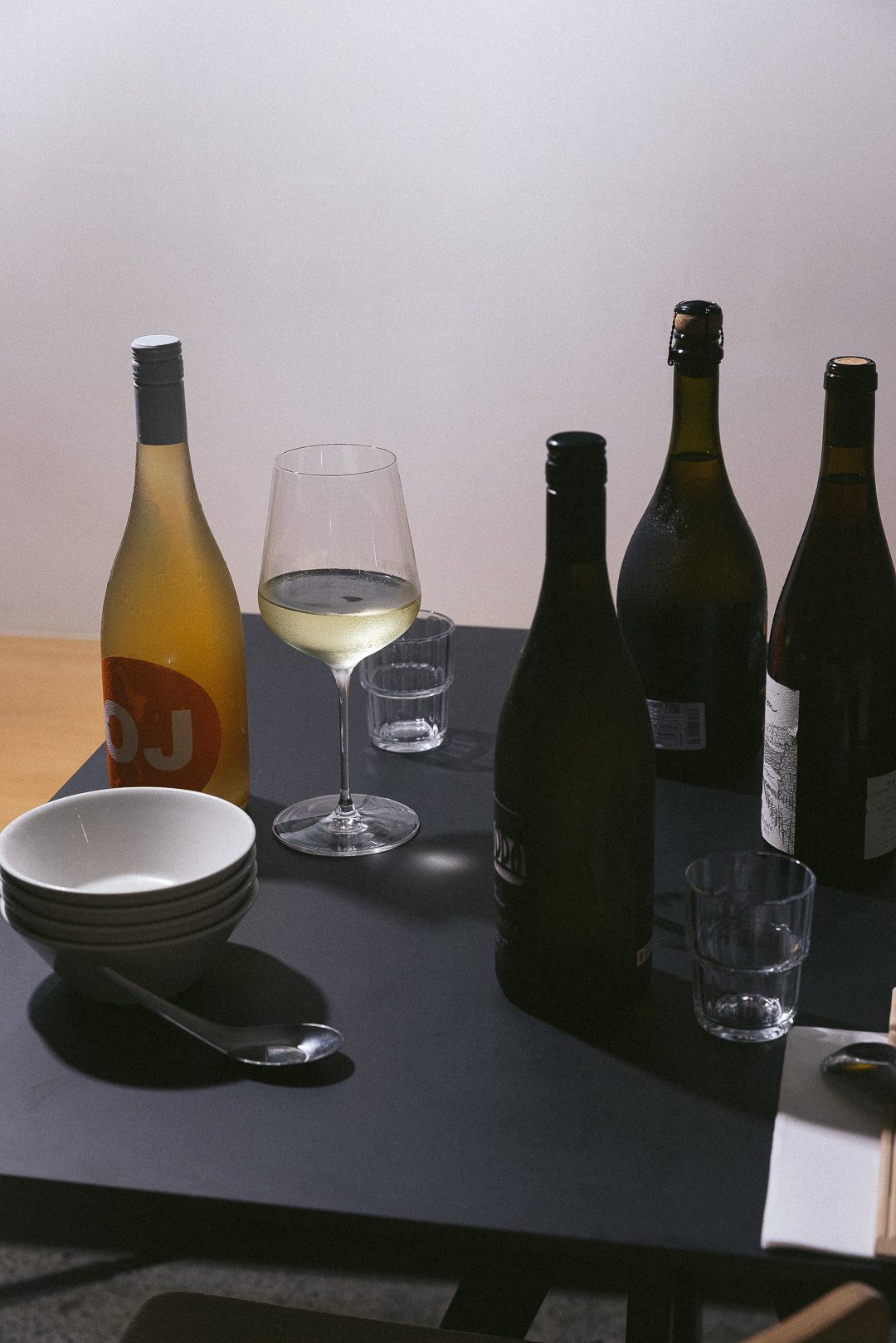 Bottles of small-producer Australian wine and poured glasses on a table at Happy Boy