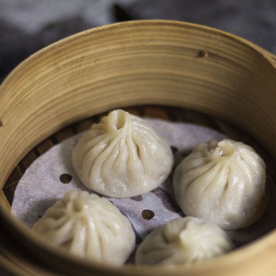 Xiaolongbao soup-filled pork dumplings in a bamboo steamer