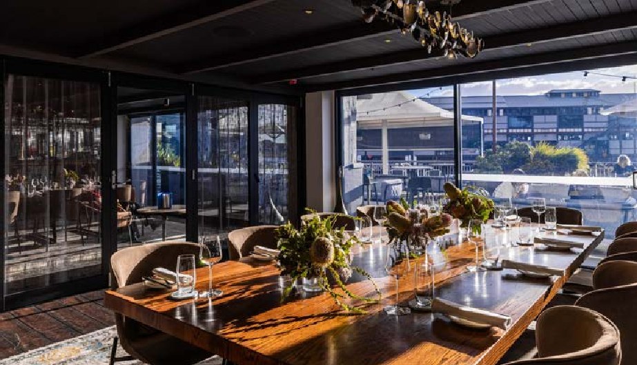 The Private Dining Room at PIER dining with a long timber table and sliding doors open onto the pier