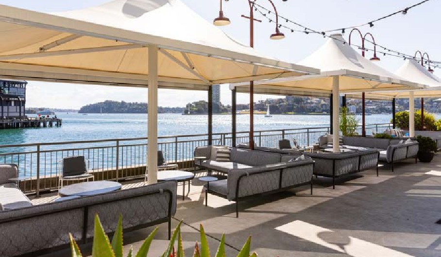 The Waterside at PIER dining with lounge seating under permanent umbrellas on the harbour edge
