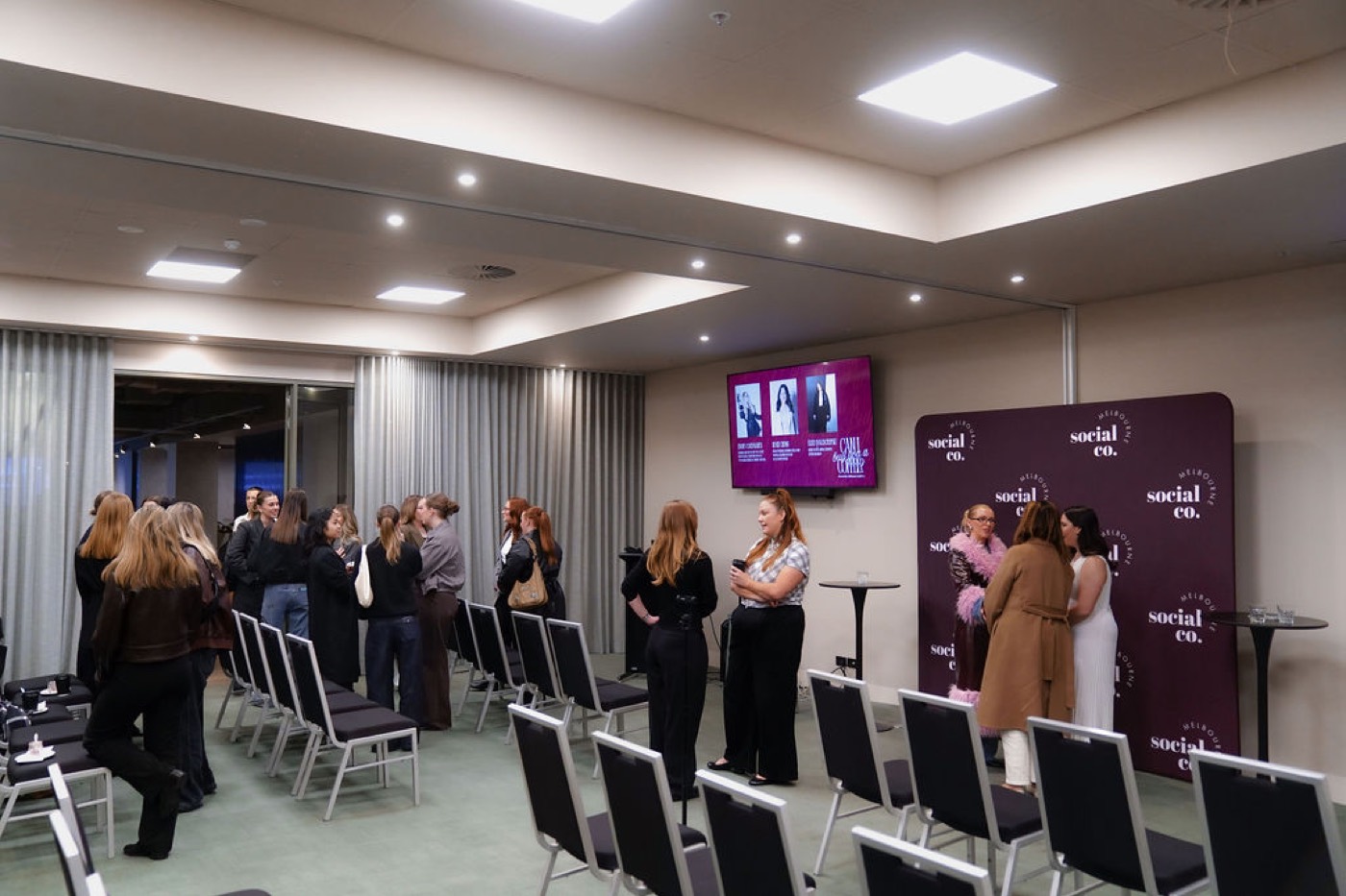 Event space set theatre-style with presentation screens and guests