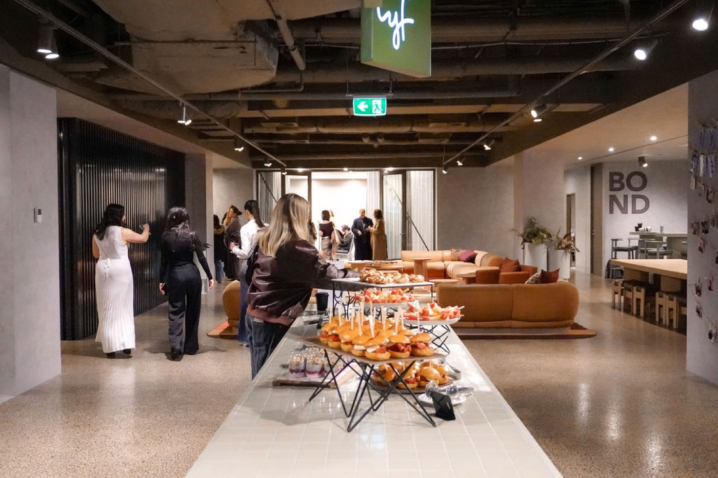 Guests mingling beside the catering table under lyf signage